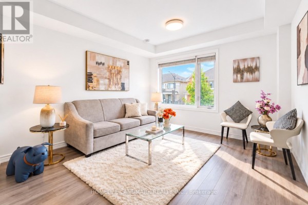 Living room with a grey sofa, glass coffee table, plush rug, and large window. - 6 Sedgemoor Street, Whitby