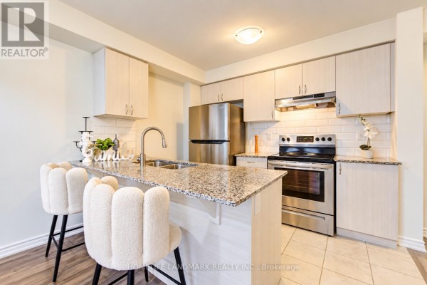 Kitchen with granite countertops, light wood cabinets, stainless steel appliances, and adjacent dining area. - 6 Sedgemoor Street, Whitby