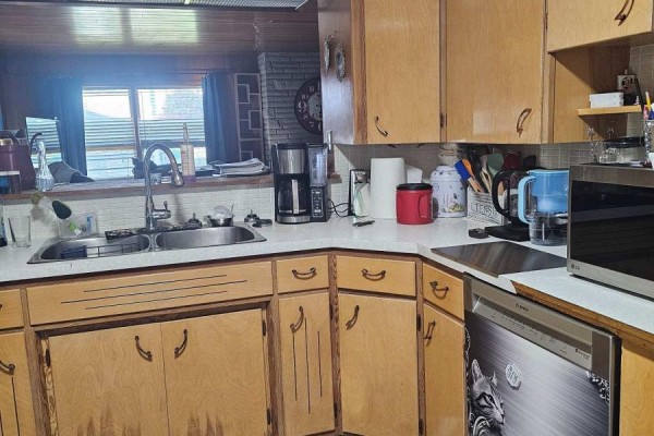 Kitchen with light wood cabinets, white countertops, double sink, coffee maker, and dishwasher. - 6 Sullivan Street, Chatham Kent