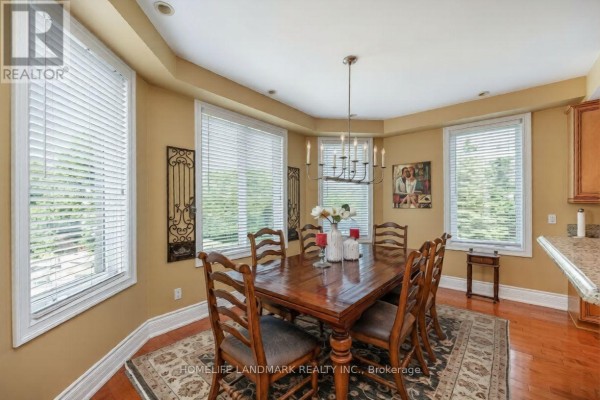 Aerial view of the home with stone exterior, landscaped gardens, and paved driveway. - 6 Sunny Ridge Trail, Clarington