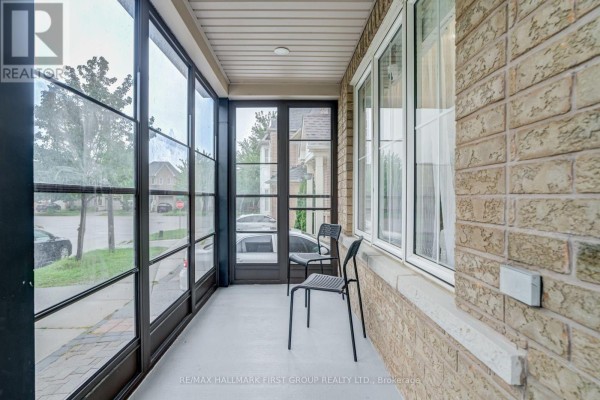 Interior view of glass-enclosed porch with two black metal chairs and view of street. - 6 Tansley Crescent, Ajax