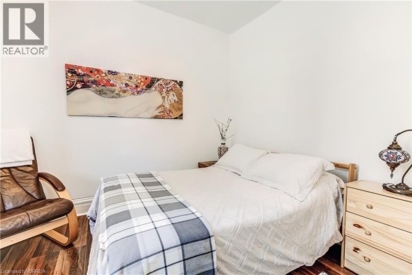 Bedroom with a double bed, plaid throw blanket, wooden dresser, and a leather accent chair. - 6 Tolhurst Avenue, St  George