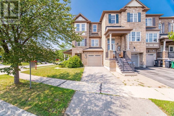 Front exterior of a brick townhouse with a paved driveway and lawn. - 6 Viewforth Road, Brampton
