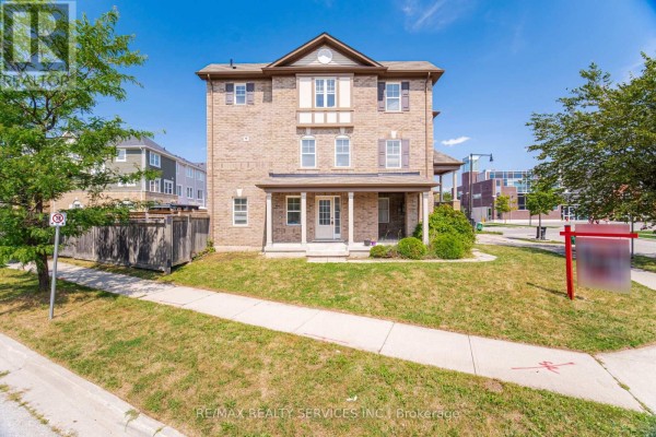 View of the front of a brick townhouse with a green lawn and sidewalks. - 6 Viewforth Road, Brampton