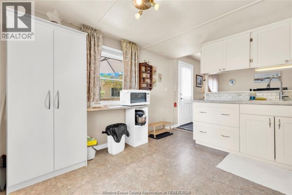 Kitchen with a large white storage cabinet, microwave, coffee maker, and a view of the backyard. - 6 Viscount, Essex