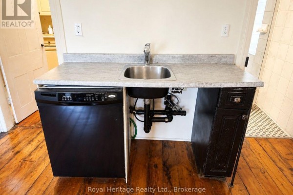 Black dishwasher and sink with grey countertop and dark wood cabinet - 6 Willard Street Belleville