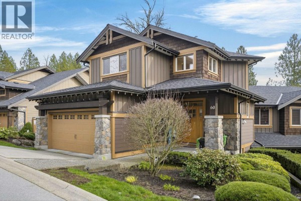 Side exterior of a townhouse with a brown facade, grey roof, and a tan garage door. - 60 24185 106b Avenue, Maple Ridge