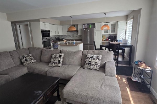 Open concept living space showing a sectional sofa and the kitchen area. - 60 Bradbrooke Drive, Yorkton