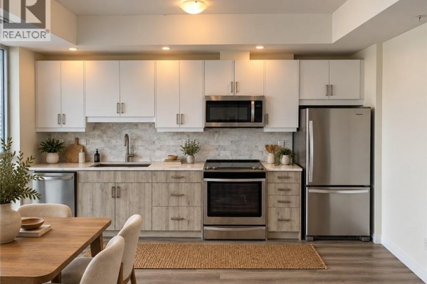 Kitchen with light wood cabinets, stainless steel appliances, and white upper cabinets. - 60 Charles Street W Unit# 2409, Kitchener
