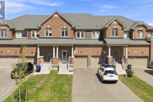 Exterior view of multiple attached townhouses with brick facades, garages, and driveways. - 60 Lorne Thomas Place, New Tecumseth
