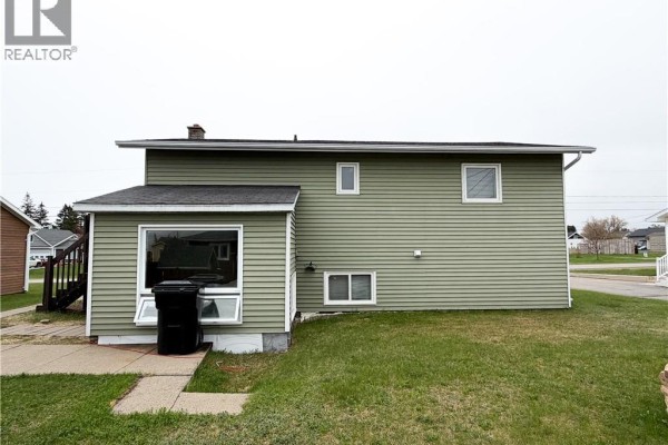 Exterior of a light green house with white trim and a large window on the side. - 60 Normandie Street, Petit Rocher