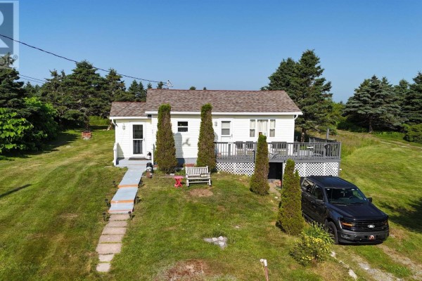 Aerial view of a residential area with a yellow house, RVs, trees, and a body of water in the distance. - 60 Red Schoolhouse Lane, North East Point