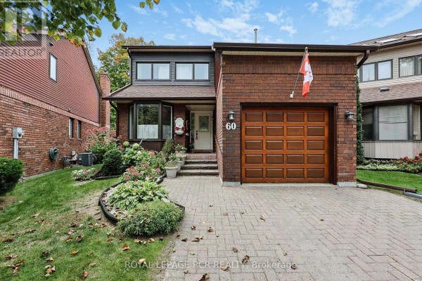 Front exterior of a two-story brick house during the day, with a paved driveway and landscaped garden. - 60 Riverview Road, New Tecumseth