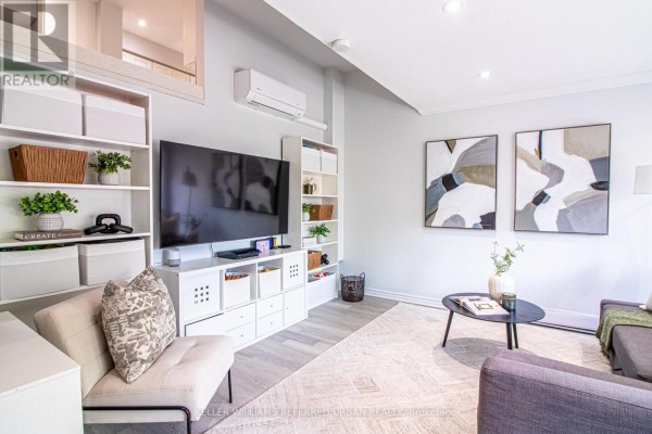 Living room with a television, entertainment unit, and two abstract paintings on the wall. - 60 Springfair Avenue, Aurora