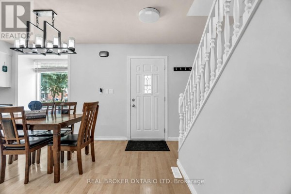 Interior view of a dining area with a wooden table and chairs, adjacent to the front entrance. - 60 Tilipe Road, London East