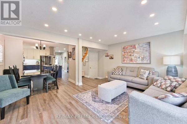 Living room and dining area with neutral walls, laminate flooring, and modern furniture. - 60 Tumbleweed Court, Vaughan