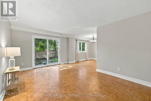 Living room with parquet flooring, sliding glass door, a chandelier, and windows. - 60 Tybalt Crescent, Ottawa