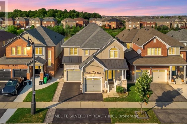 Front exterior of a beige and brick two-story house with a grey roof and double garage. - 60 Tysonville Circle, Brampton