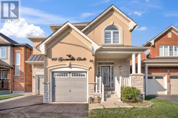 Close-up exterior view of the beige and stone facade of a two-story house with a garage. - 60 Tysonville Circle, Brampton