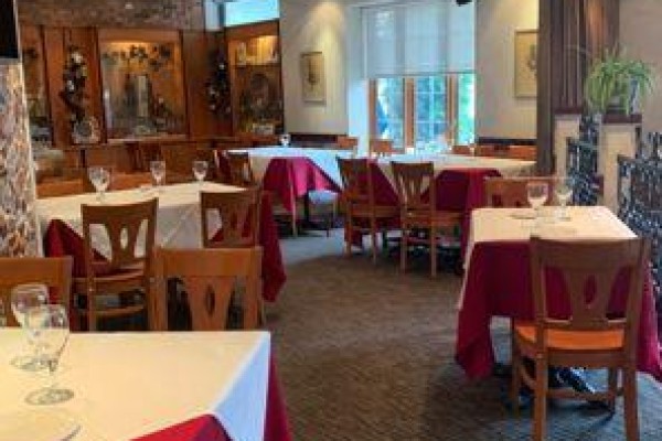 Dining room with tables covered in red and white cloths, chairs, and windows. - 60 Walnut Street, Hamilton