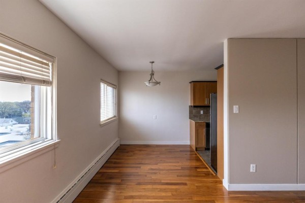 Interior apartment space showing a dining area and kitchen with wood cabinets. - 600 565 Corydon Avenue, Winnipeg