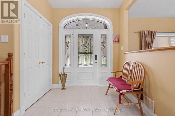 Foyer with tiled floor, white double doors, arched entryway with stained glass. - 600 Crozier Road, North Grenville