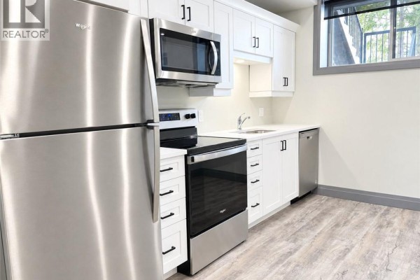 Modern kitchen with white cabinets, stainless steel appliances, and a dishwasher. - 600 Norfolk Street Unit# 104, Simcoe