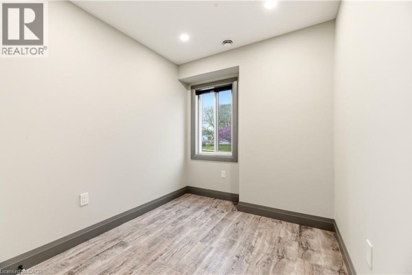 Small empty room with grey trim, light walls, and a window with outdoor view. - 600 Norfolk Street Unit# 104, Simcoe