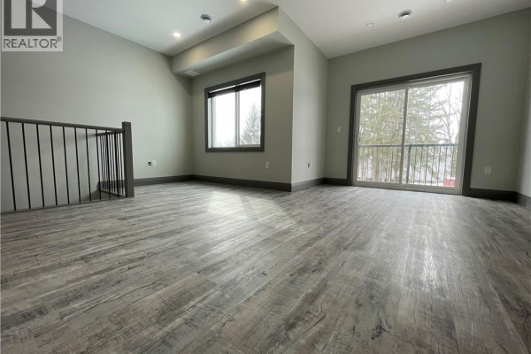 Open concept living space with large window and sliding glass doors to a balcony. - 600 Norfolk Street Unit# 301, Simcoe
