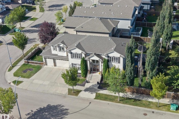 Close-up of the front entrance stairs and double brown doors of a beige house with stone accents. - 6002 46 Av, Beaumont