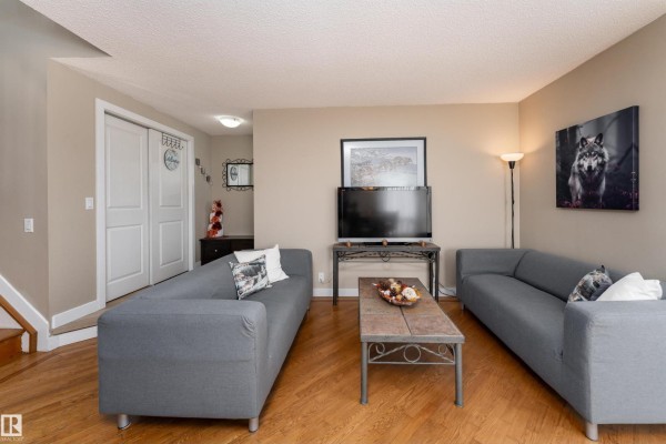 Living room with two gray sofas, a coffee table, and a television facing the sofas. - 6007 37 Av Nw, Edmonton