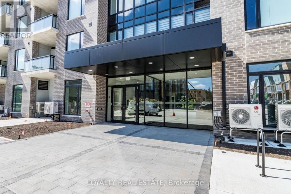 Entrance to the apartment building with glass doors and dark grey awning. - 601 - 103 Rogers Street, Waterloo