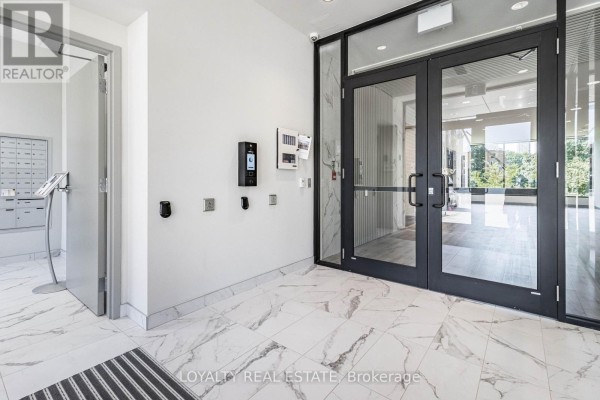 Interior lobby with marble tile flooring, mailboxes, and intercom system. - 601 - 103 Rogers Street, Waterloo