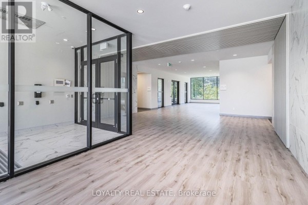 Interior apartment building lobby with glass partition and expansive hallway view. - 601 - 103 Rogers Street, Waterloo