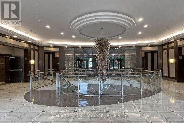 Spacious condo lobby with marble floors and modern chandelier. - 601 - 133 Wynford Drive, Toronto