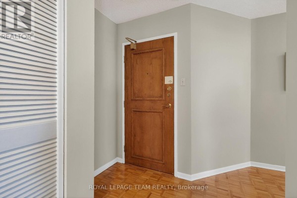Compact kitchen featuring white appliances, light cabinetry, and a pass-through to the dining area. - 601 - 40 Arthur Street, Ottawa