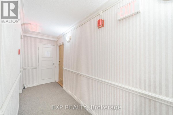 Apartment entryway with a closet containing a stacked washer and dryer, and a light wood door. - 601 - 432 Main Street E, Hamilton