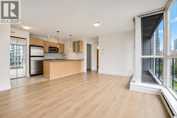 Open concept living area with light wood floors, kitchen with light wood cabinets and stainless steel appliances. - 601 1199 Seymour Street, Vancouver