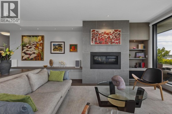 Living room with a gas fireplace, ample natural light, and decorative artwork. - 601 4427 Cambie Street, Vancouver
