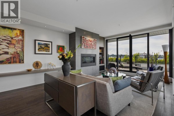 Spacious living area with a fireplace, large windows, and a balcony view. - 601 4427 Cambie Street, Vancouver