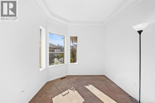A small room with a bay window, carpet, and white walls. - 601 4515 Pipeline Rd, Saanich