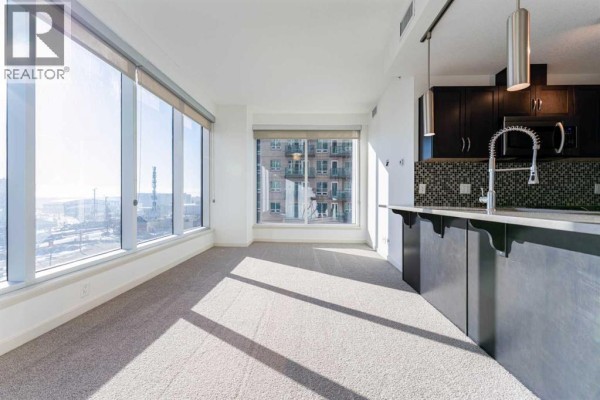 Bright living space with carpet flooring and city view - 602, 1320 1 Street Se, Calgary