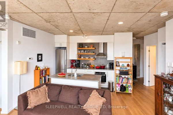 Kitchen area with white cabinets, stainless steel appliances, and a large island. - 602 - 1000 Wellington Street W, Ottawa