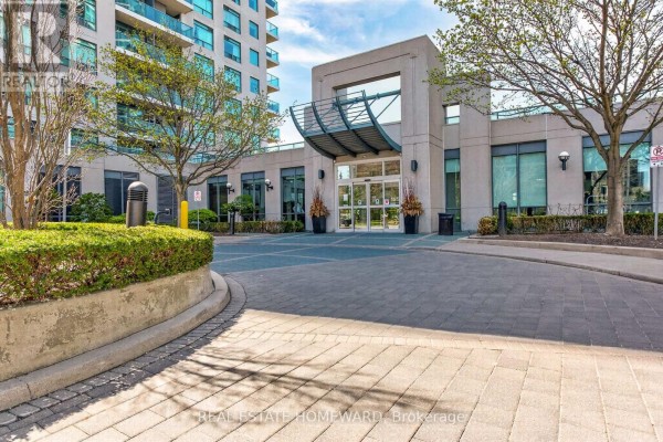 Entrance to apartment building with paved driveway and manicured bushes. - 602 - 30 Harrison Garden Boulevard, Toronto
