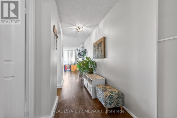 Living room with sectional sofa, electric fireplace, and large windows overlooking the city. - 602 - 30 Harrison Garden Boulevard, Toronto