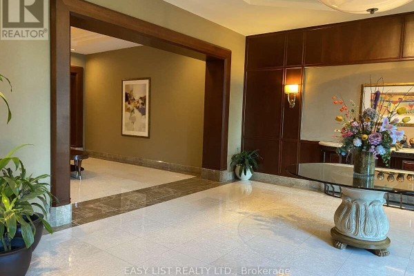 Building lobby with marble floors, wood paneling, and decorative artwork. - 602 - 3590 Rivergate Way, Ottawa