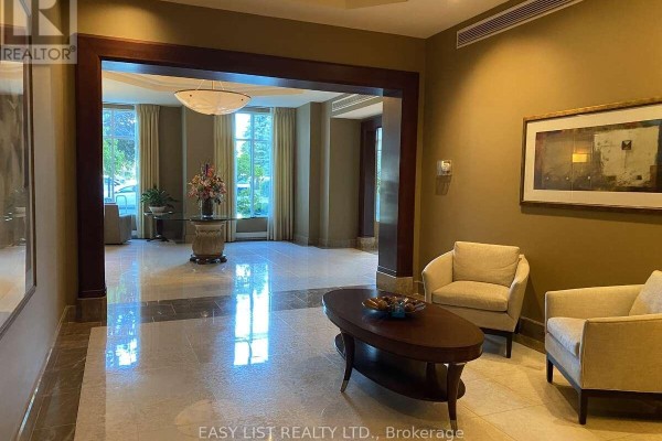 Building lobby with seating area, marble floors, and large windows. - 602 - 3590 Rivergate Way, Ottawa
