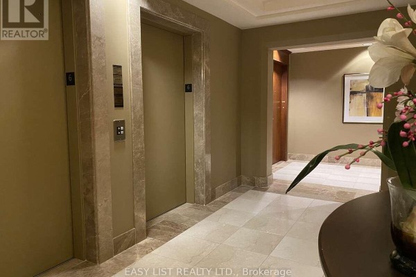 Building hallway with two elevators, marble accents, and tiled flooring. - 602 - 3590 Rivergate Way, Ottawa