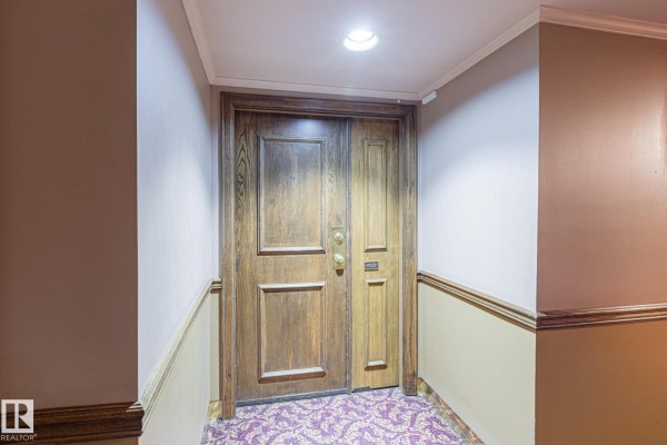 Cozy lounge area with leather furniture, chandelier, and decorative accents. - #602 11503 100 Av Nw, Edmonton