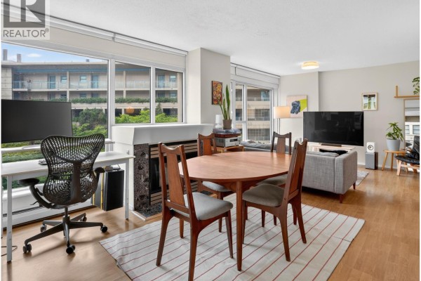 Living and dining area with sofa, bookshelves, balcony access, and desk with computer. - 602 183 Keefer Place, Vancouver